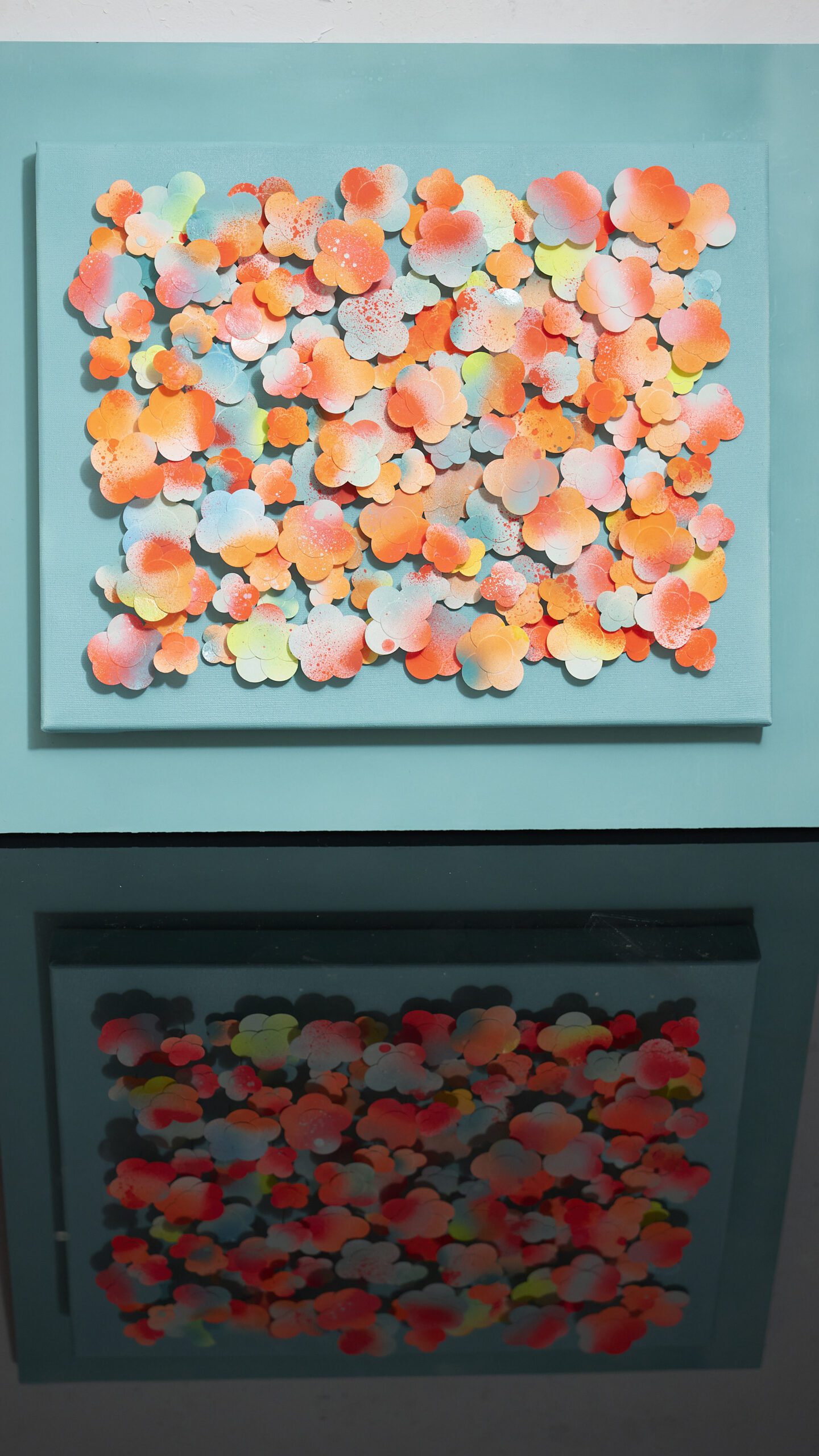 Neon Oasis painting, 55x60 cm, in vibrant turquoise and neon hues, displayed with its colors reflecting softly on a table. The bold, luminous tones create a striking contrast, enhancing the 3D texture of the artwork and adding a dynamic, radiant ambiance.